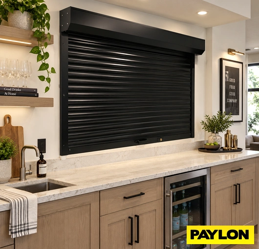 Black roll-up counter shutter above a home bar with a sink and wine cooler.