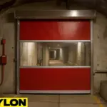 Motorized Roll-Up Vinyl Door installed in a theme park maintenance tunnel, featuring a red vinyl panel with a clear vision window for visibility and secure access