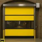 Roll-Up Vinyl Door Motorized in a brick-arched theme park tunnel, featuring a clear vision panel revealing an industrial interior with pipes, catwalks, and overhead lighting