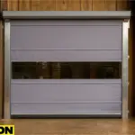 Creative use of roll-up doors in livestock and agricultural barns, featuring a high-speed vinyl door installed in a wood-paneled barn facility with a visible farm interior