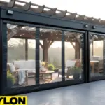 Motorized clear vinyl pavilion curtains in a black frame enclosure, showcasing a protected outdoor seating area with clear views of the yard.