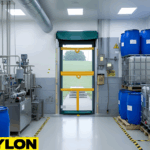 Roll Up Bug Door used in a chemical processing facility with tanks, blue drums, and ventilation equipment.