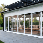 White-frame pavilion with motorized clear vinyl curtains lowered to enclose the space, creating a clean, bright outdoor rooms