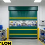 Green vinyl roll-up door separating clean manufacturing workspaces to support controlled access and room separation