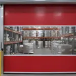 High-speed red vinyl roll-up door separating pallets of wine and inventory in a climate-controlled warehouse.