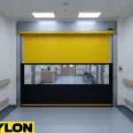 High-visibility yellow roll-up vinyl door in a healthcare corridor, helping manage movement flow and access between facility areas.