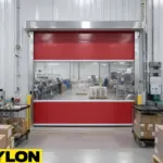 Red vinyl roll-up door dividing packaging and processing areas inside a manufacturing facility