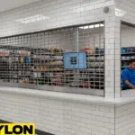 Retail service counter with a metal roll-up counter door separating staff workspace from customer area