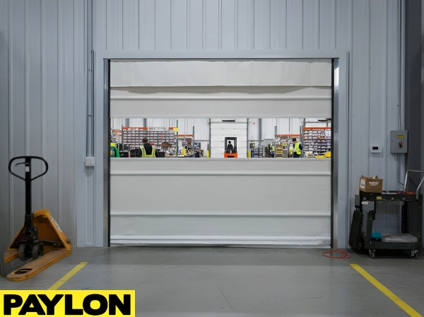 Roll-up vinyl door dividing production and packaging zones in a busy distribution facility