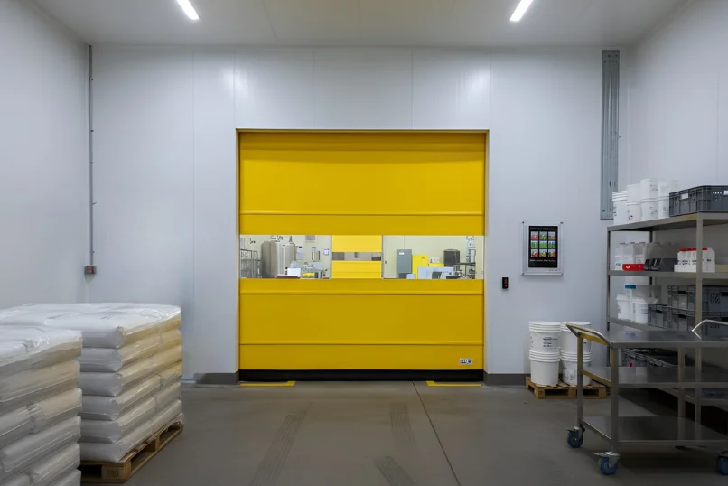 Roll-up vinyl door separating active dairy processing and storage work areas with clear access and visibility