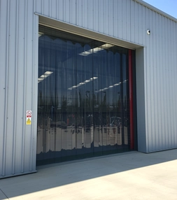 Vinyl strip curtains installed at a loading dock door to control temperature and keep out debris.