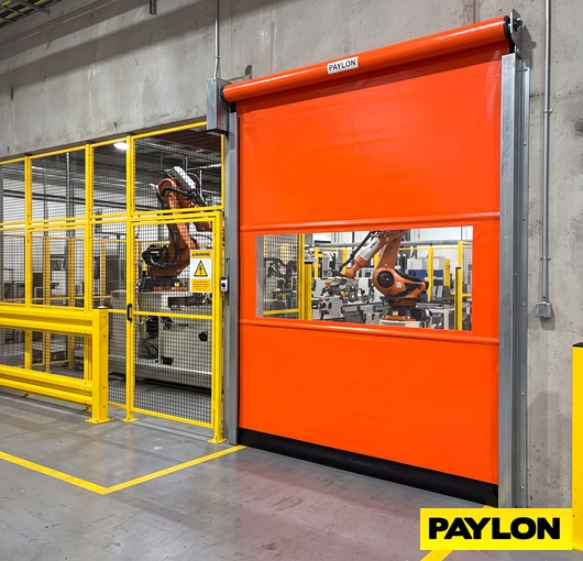 An automated roll up door installed at an industrial or commercial facility entrance, shown in operational position.