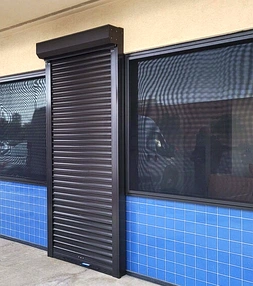Security screens installed on a commercial or industrial building to restrict unauthorized access while maintaining ventilation.